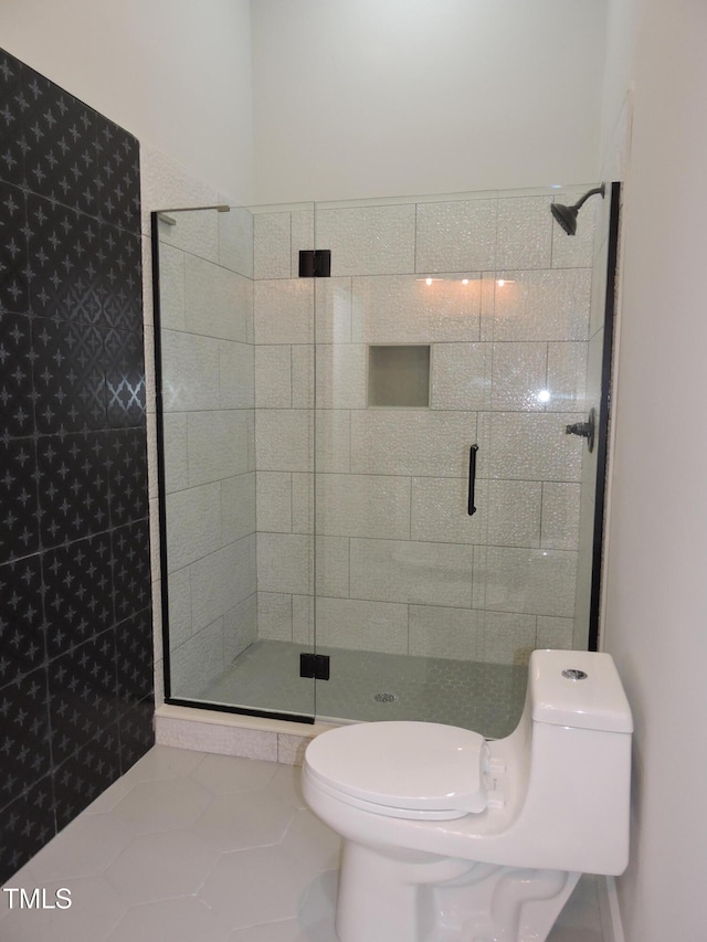 bathroom with a shower with door, tile patterned flooring, and toilet