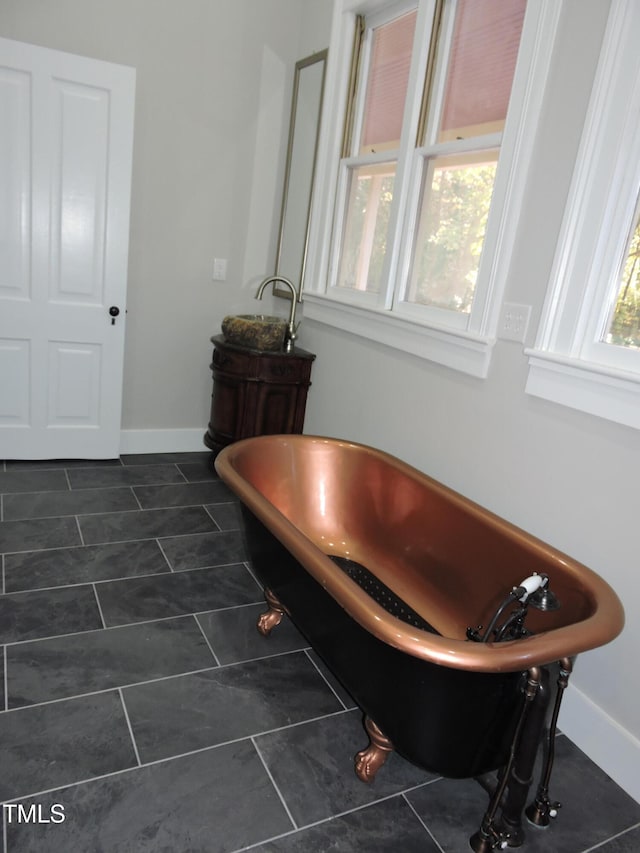 bathroom with a bathing tub, plenty of natural light, and tile patterned floors