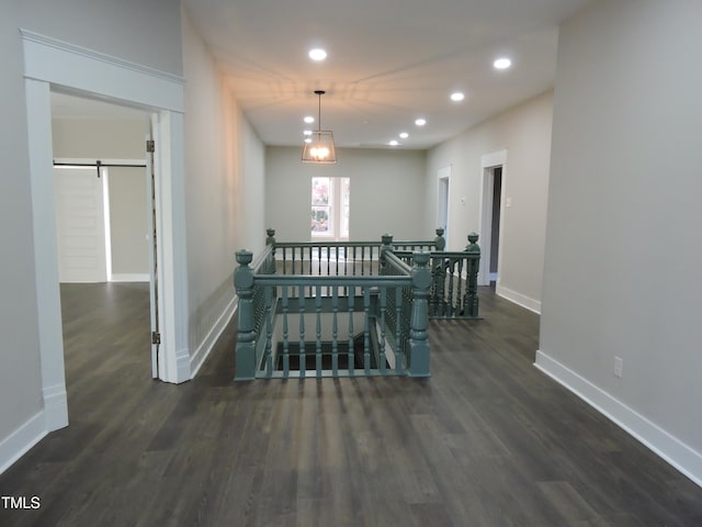 hall with dark hardwood / wood-style flooring and a barn door