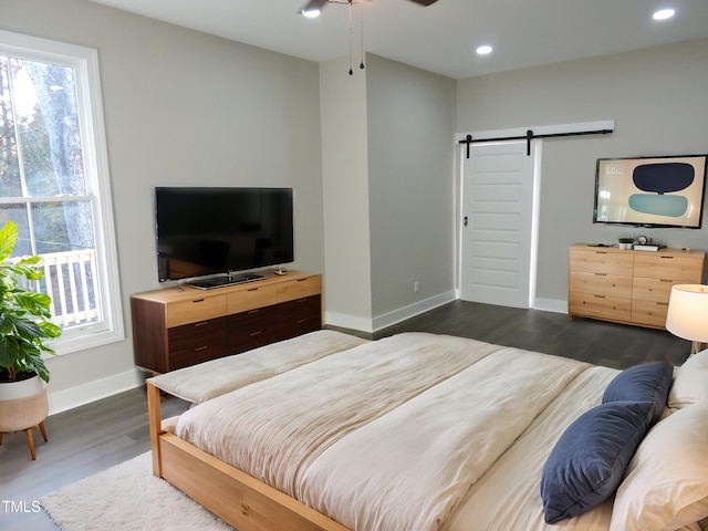 bedroom featuring dark wood-type flooring and a barn door