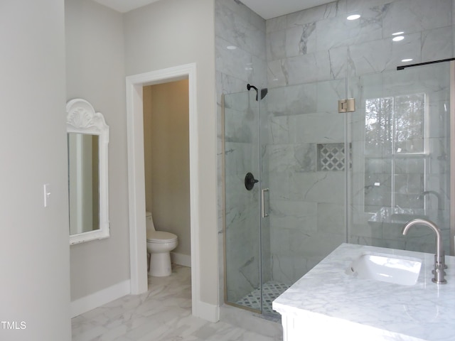 bathroom with vanity, toilet, and a shower with door