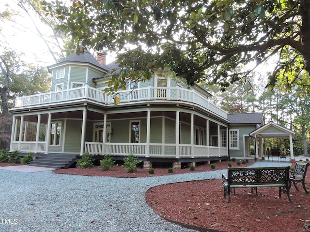 back of property with a porch and a balcony