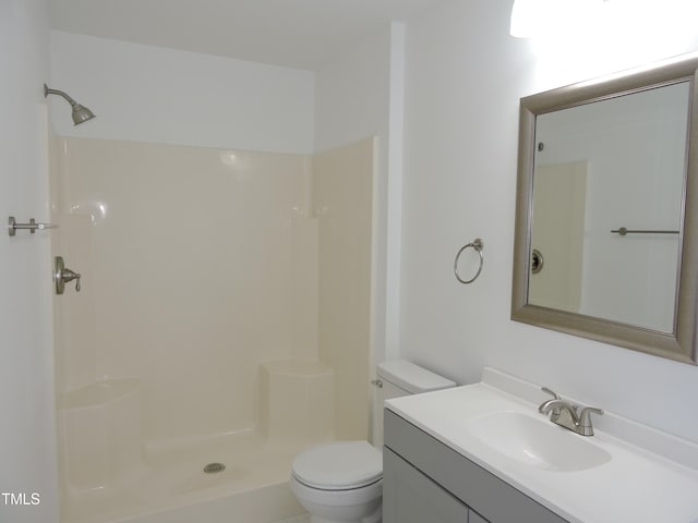 bathroom featuring walk in shower, vanity, and toilet