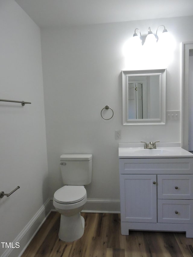 bathroom featuring toilet, vanity, and wood-type flooring