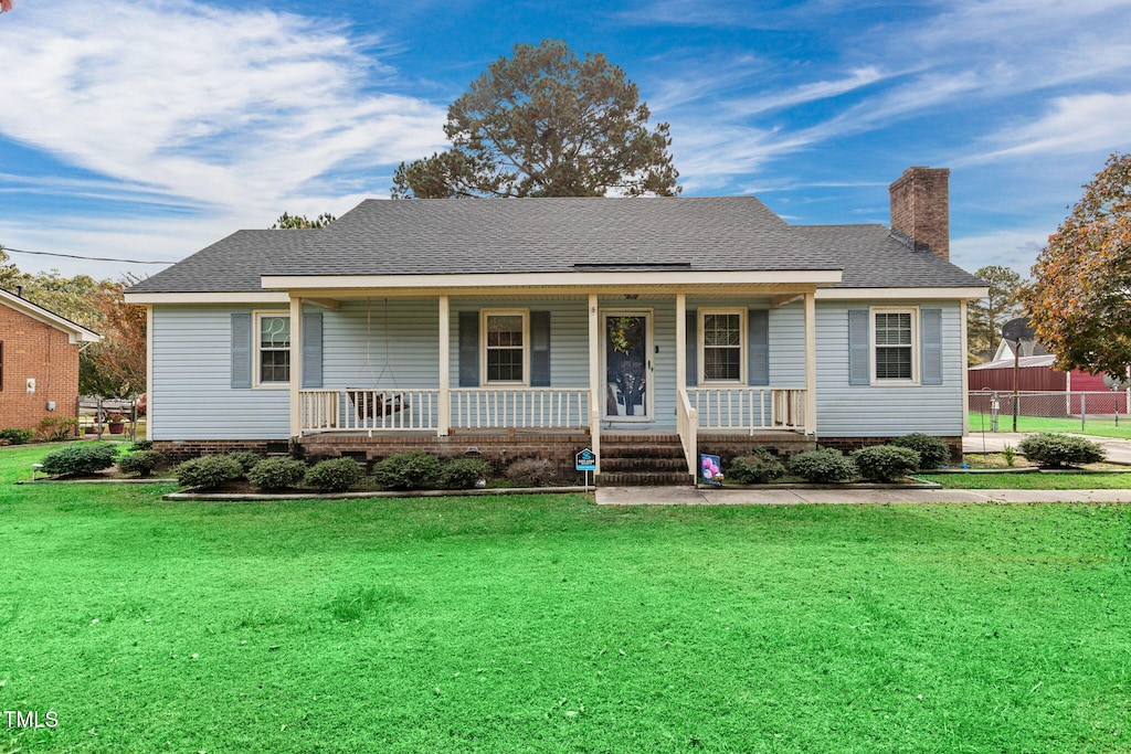 ranch-style home featuring a porch and a front yard