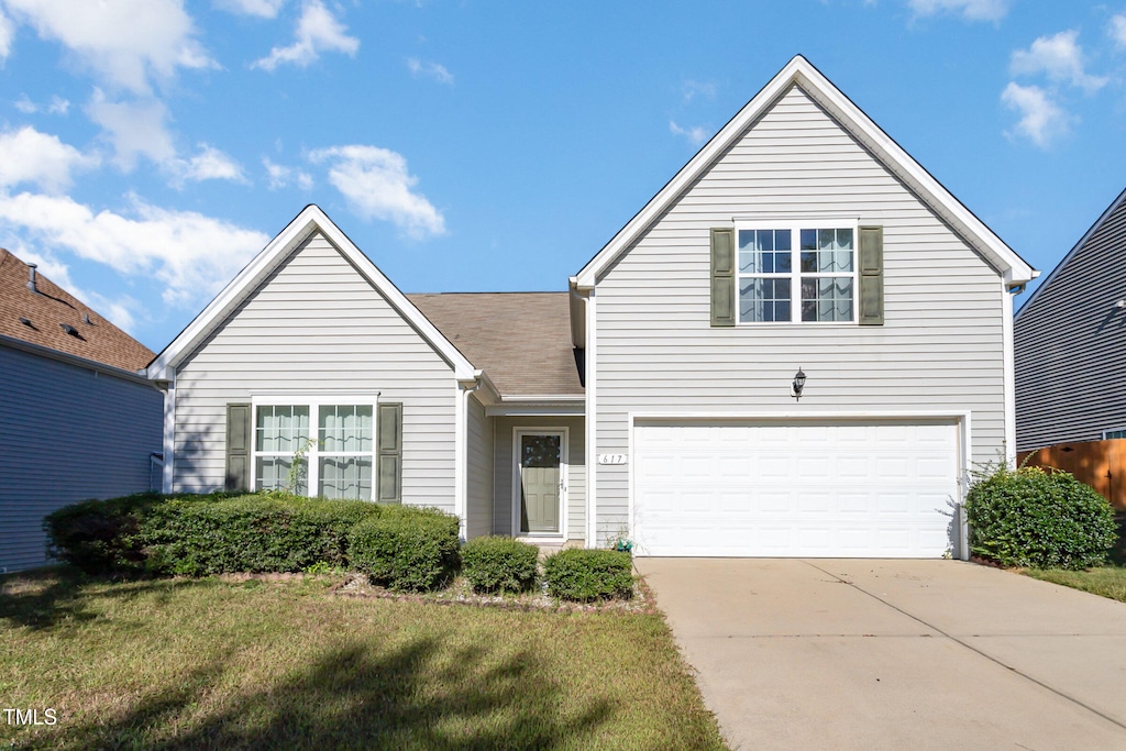 view of property with a front lawn and a garage