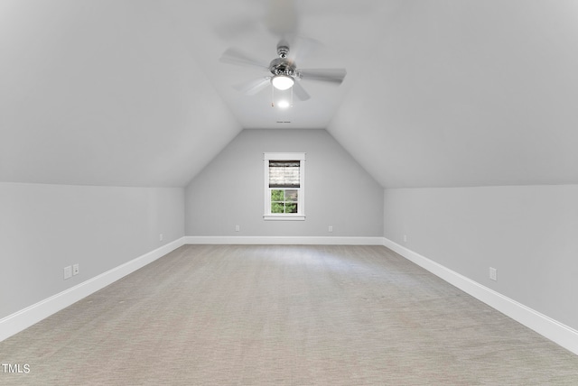 additional living space featuring vaulted ceiling, light carpet, and ceiling fan