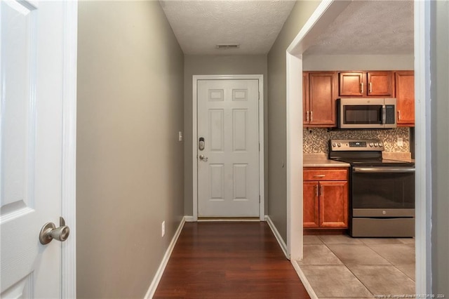 doorway to outside featuring light hardwood / wood-style floors and a textured ceiling