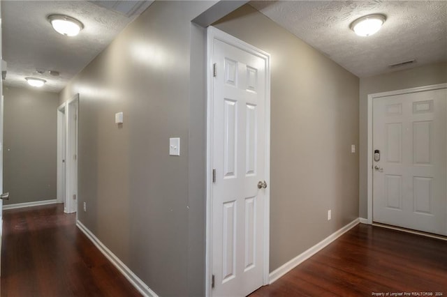 hall featuring a textured ceiling and dark hardwood / wood-style flooring