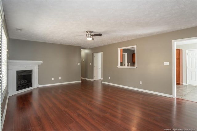 unfurnished living room with hardwood / wood-style floors, ceiling fan, and a textured ceiling