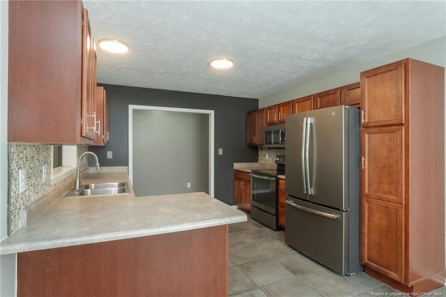 kitchen featuring a textured ceiling, sink, light tile patterned floors, backsplash, and appliances with stainless steel finishes