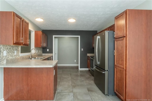 kitchen with stainless steel appliances, sink, kitchen peninsula, light tile patterned floors, and backsplash