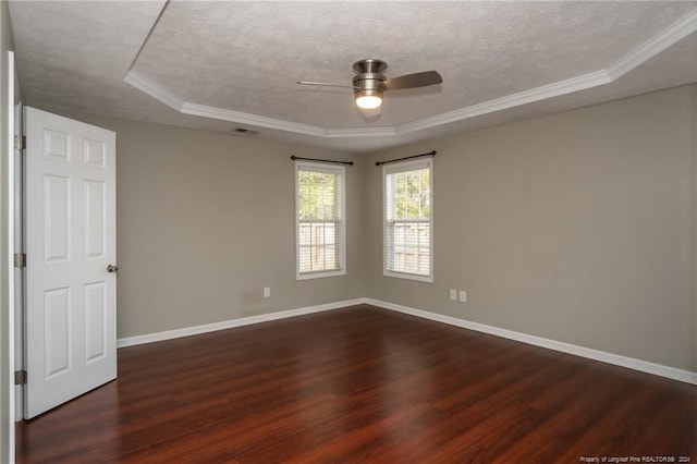 empty room featuring dark hardwood / wood-style floors, a raised ceiling, and ceiling fan