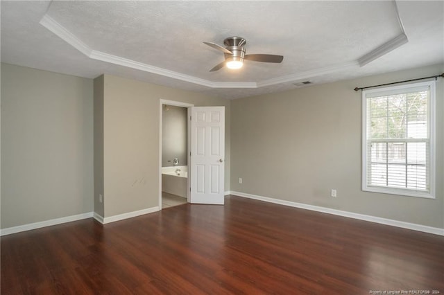 unfurnished bedroom with ceiling fan, dark hardwood / wood-style flooring, and a tray ceiling