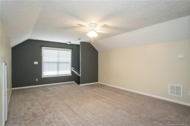 additional living space featuring light colored carpet, lofted ceiling, and ceiling fan