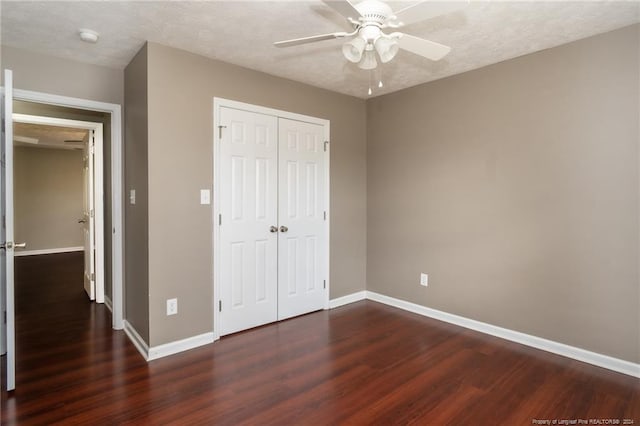 unfurnished bedroom with a textured ceiling, ceiling fan, dark hardwood / wood-style floors, and a closet