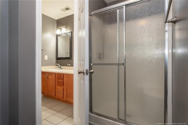 bathroom with walk in shower, vanity, and tile patterned floors