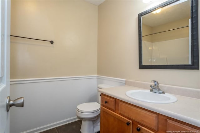 bathroom featuring walk in shower, tile patterned flooring, vanity, and toilet