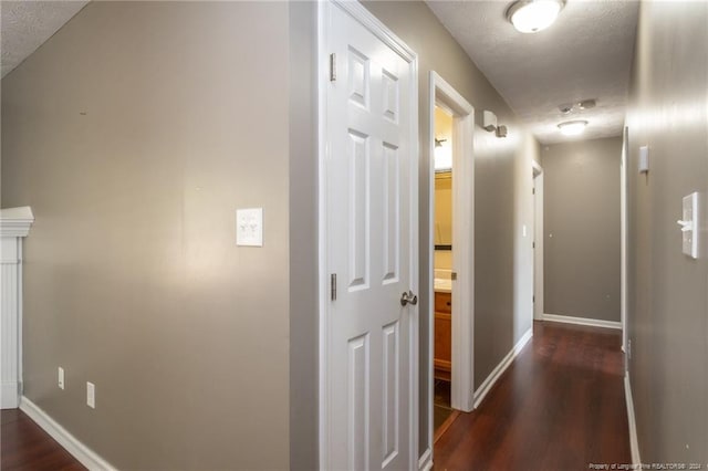 hallway featuring dark wood-type flooring and a textured ceiling