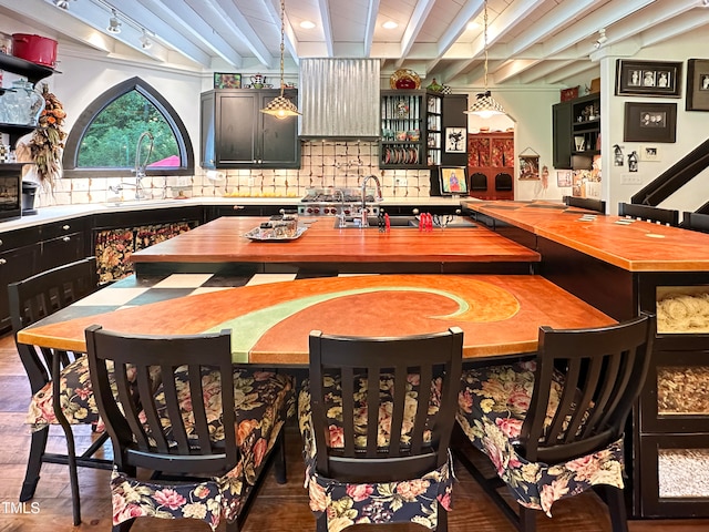 bar featuring beamed ceiling, decorative light fixtures, dark hardwood / wood-style floors, and sink