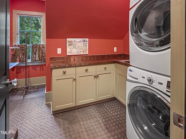 laundry area featuring cabinets and stacked washer and clothes dryer