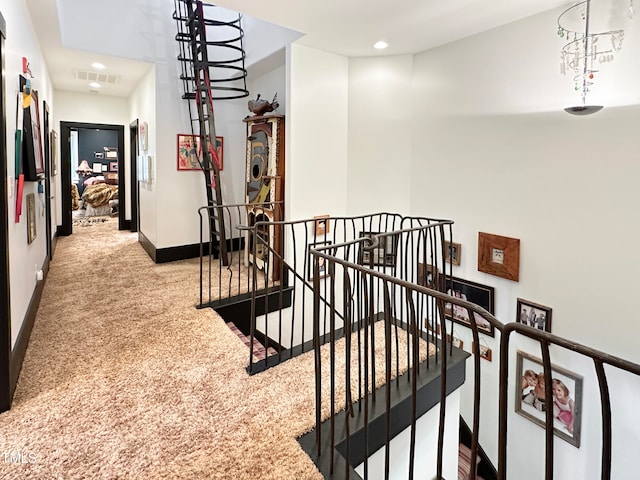 corridor featuring a notable chandelier and light carpet