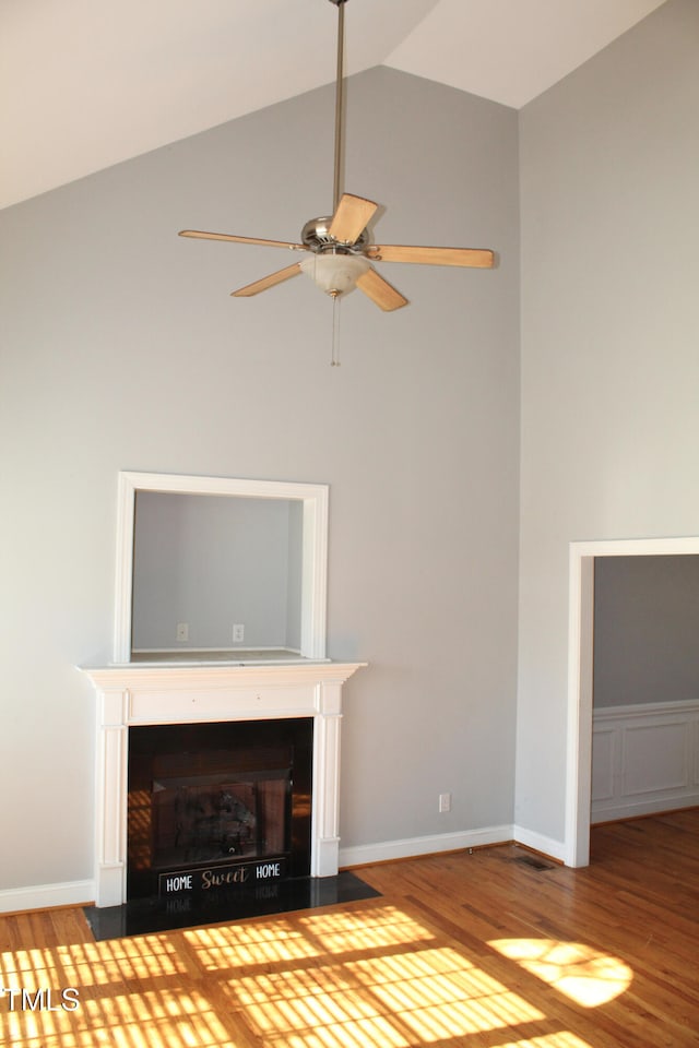 unfurnished living room featuring wood-type flooring, ceiling fan, and high vaulted ceiling