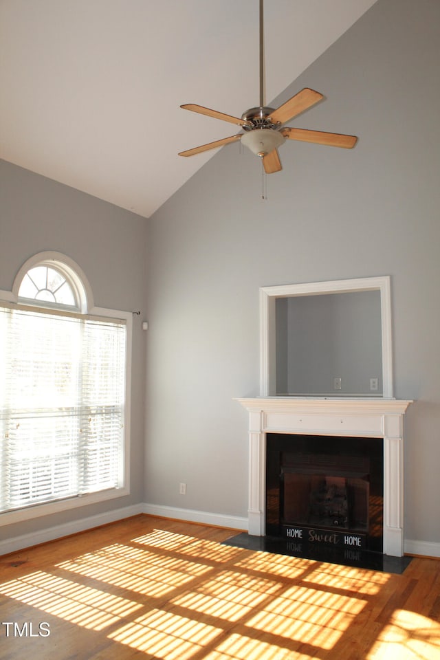 unfurnished living room with ceiling fan, high vaulted ceiling, and light hardwood / wood-style flooring