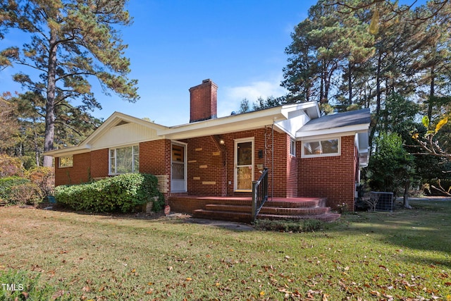 view of front of house with central air condition unit and a front yard