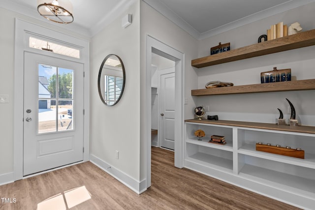 entrance foyer featuring ornamental molding and light hardwood / wood-style flooring