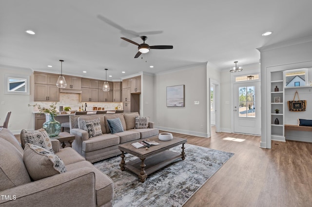 living room with ceiling fan, crown molding, and light hardwood / wood-style floors