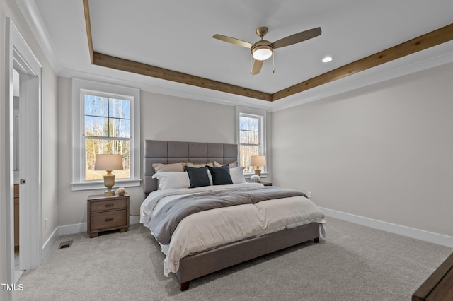 carpeted bedroom with a raised ceiling and ceiling fan