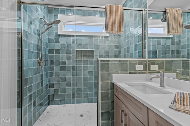 bathroom with a tile shower and vanity