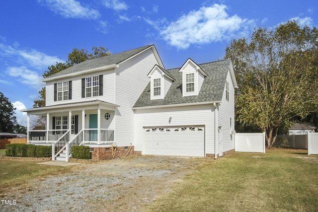 view of front of property featuring a garage, a front yard, and covered porch