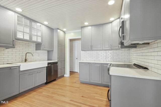 kitchen featuring light wood-type flooring, appliances with stainless steel finishes, gray cabinets, and sink