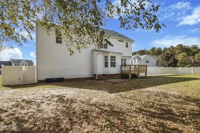 rear view of property featuring a lawn and a wooden deck