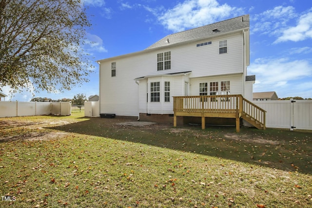 back of house featuring a deck and a lawn