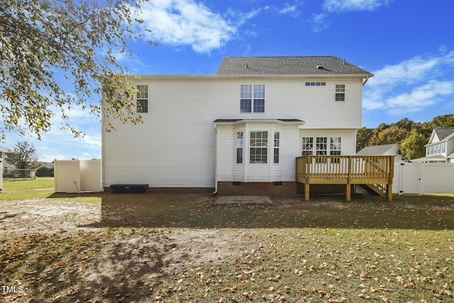 rear view of house featuring a deck and a yard