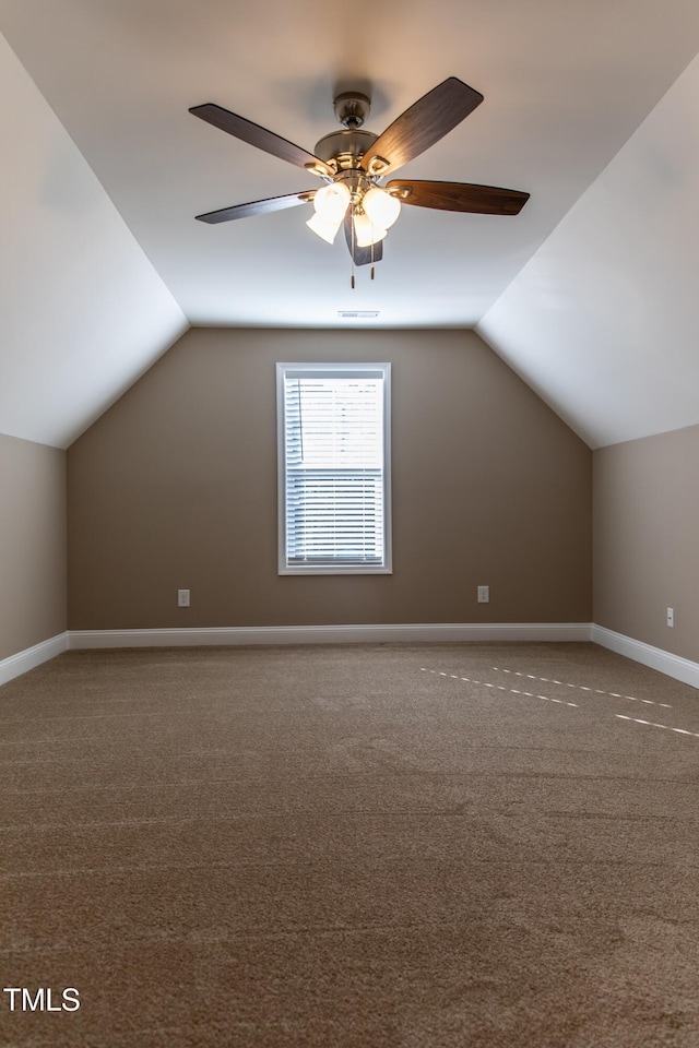 additional living space with carpet flooring, ceiling fan, and vaulted ceiling