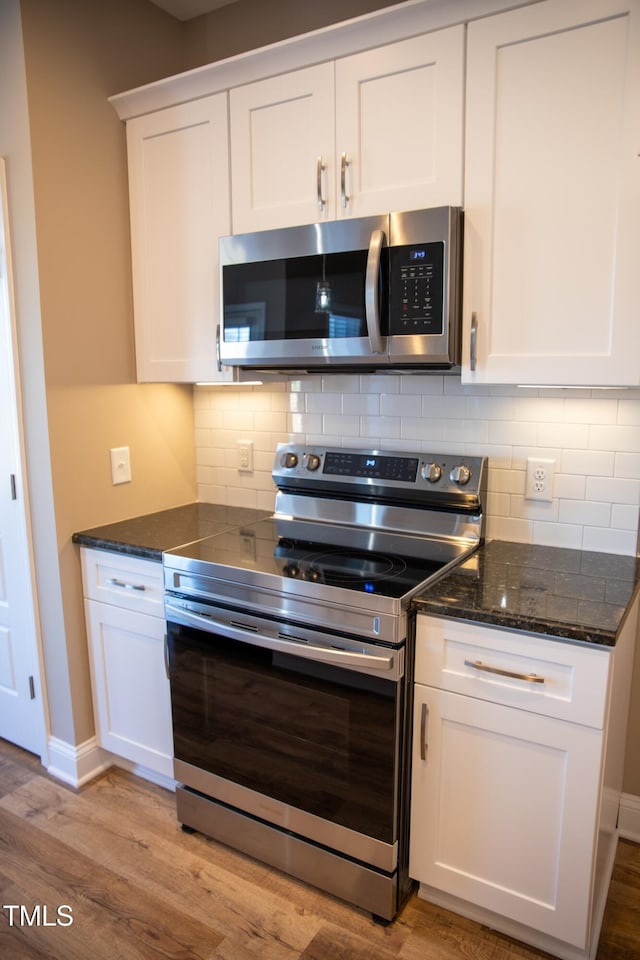 kitchen with backsplash, light wood-type flooring, white cabinetry, and stainless steel appliances