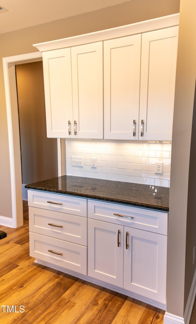 bar featuring white cabinets and light hardwood / wood-style floors