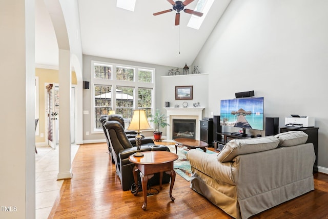 living room featuring hardwood / wood-style flooring, high vaulted ceiling, and ceiling fan