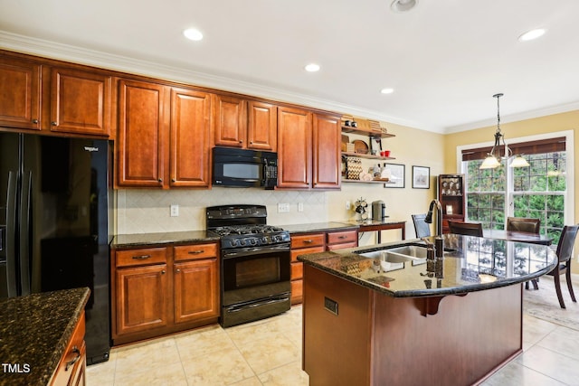 kitchen with sink, light tile patterned floors, black appliances, and a center island with sink