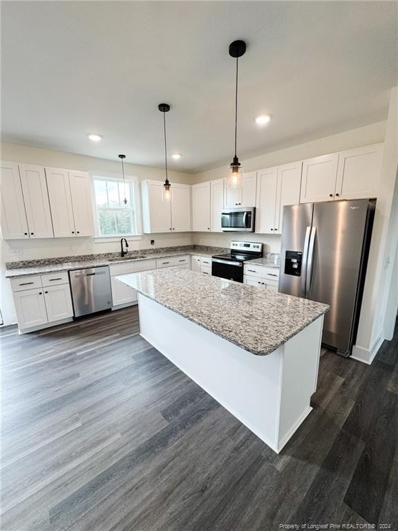 kitchen featuring stainless steel appliances, white cabinetry, pendant lighting, and a center island