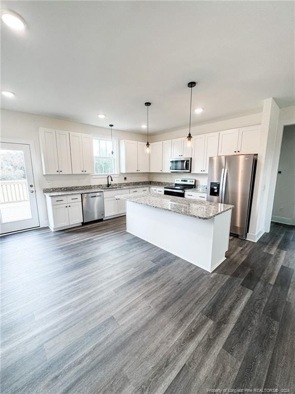 kitchen with white cabinetry, appliances with stainless steel finishes, and hanging light fixtures