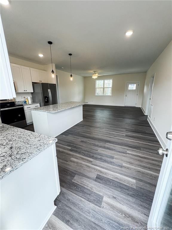 kitchen featuring white cabinetry, light stone countertops, a center island, dark wood-type flooring, and stainless steel fridge with ice dispenser