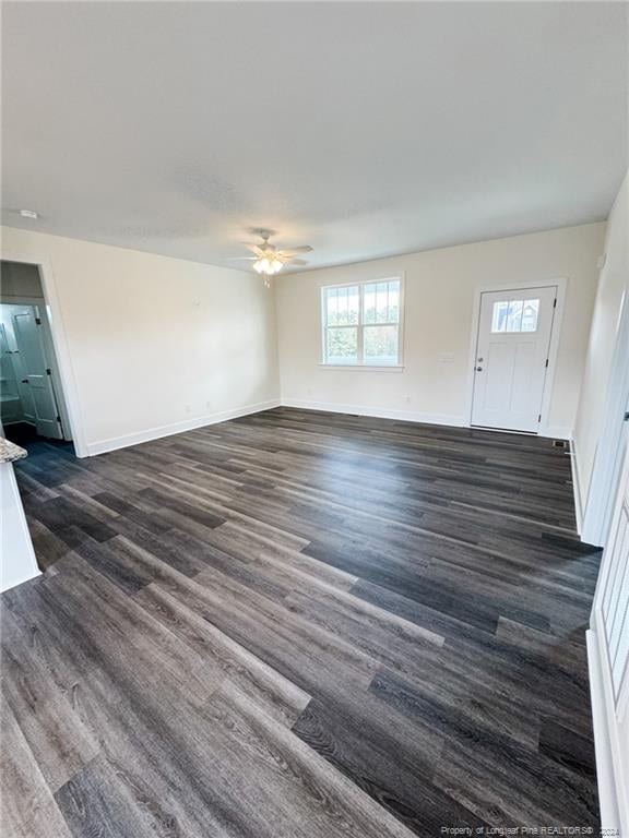 unfurnished living room featuring ceiling fan and dark hardwood / wood-style floors