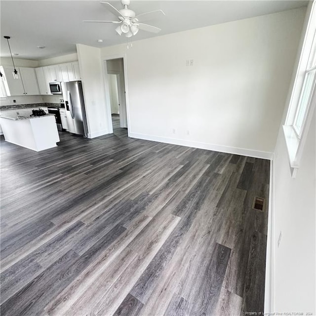 kitchen featuring dark hardwood / wood-style floors, ceiling fan, white cabinetry, appliances with stainless steel finishes, and decorative light fixtures