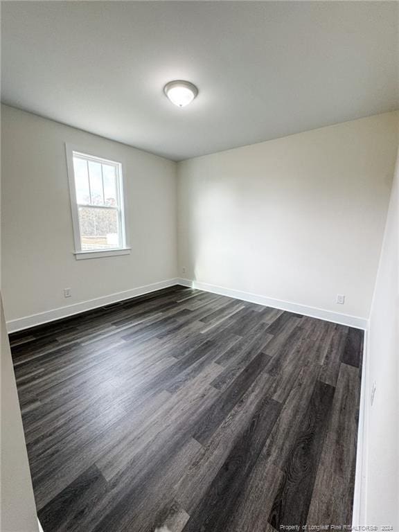 empty room with dark hardwood / wood-style flooring