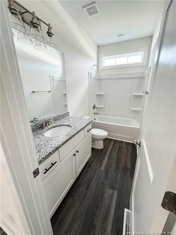 full bathroom with shower / washtub combination, hardwood / wood-style flooring, toilet, and vanity